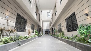 A modern building with a central corridor flanked by windows and decorative panels, leading to a door. - Silkhaus Safa 47 A (Riyadh)