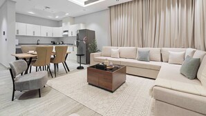 En moderne stue med sofa, sofabord og spiseplads.