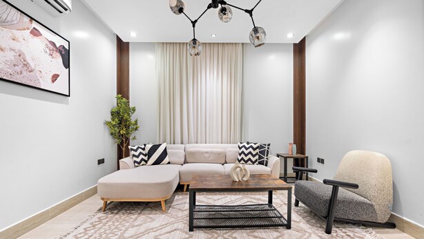 A modern living room with a sectional sofa, a coffee table, and a recliner. - Silkhaus Majidia 77 (Riyadh)