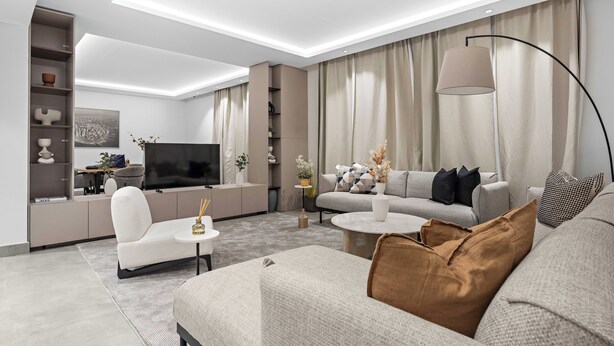 A modern living room with a sofa, armchair, and coffee table, a flat-screen TV, and a floor lamp. - Silkhaus Rose Residency 36 (Riyadh)