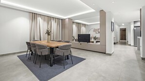 A modern hotel room with a dining area, a flat-screen TV, and a kitchenette. - Silkhaus Rose Residency 36 (Riyadh)