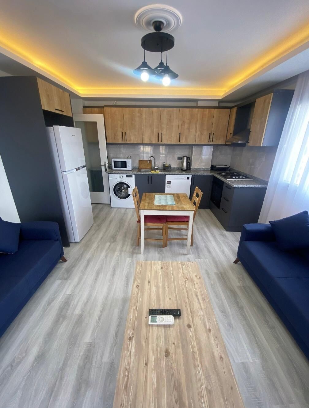 A compact living space with a kitchenette, a dining area, and a sofa.
