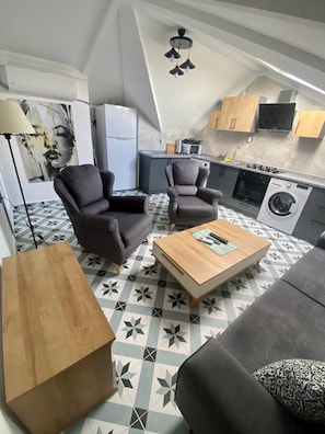 Loft económico, cocina | Área de sala de estar | Televisión de pantalla plana de 82 pulgadas con canales vía satélite 