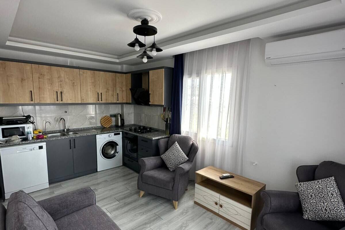 A modern apartment with a kitchen, dining area, and living room.