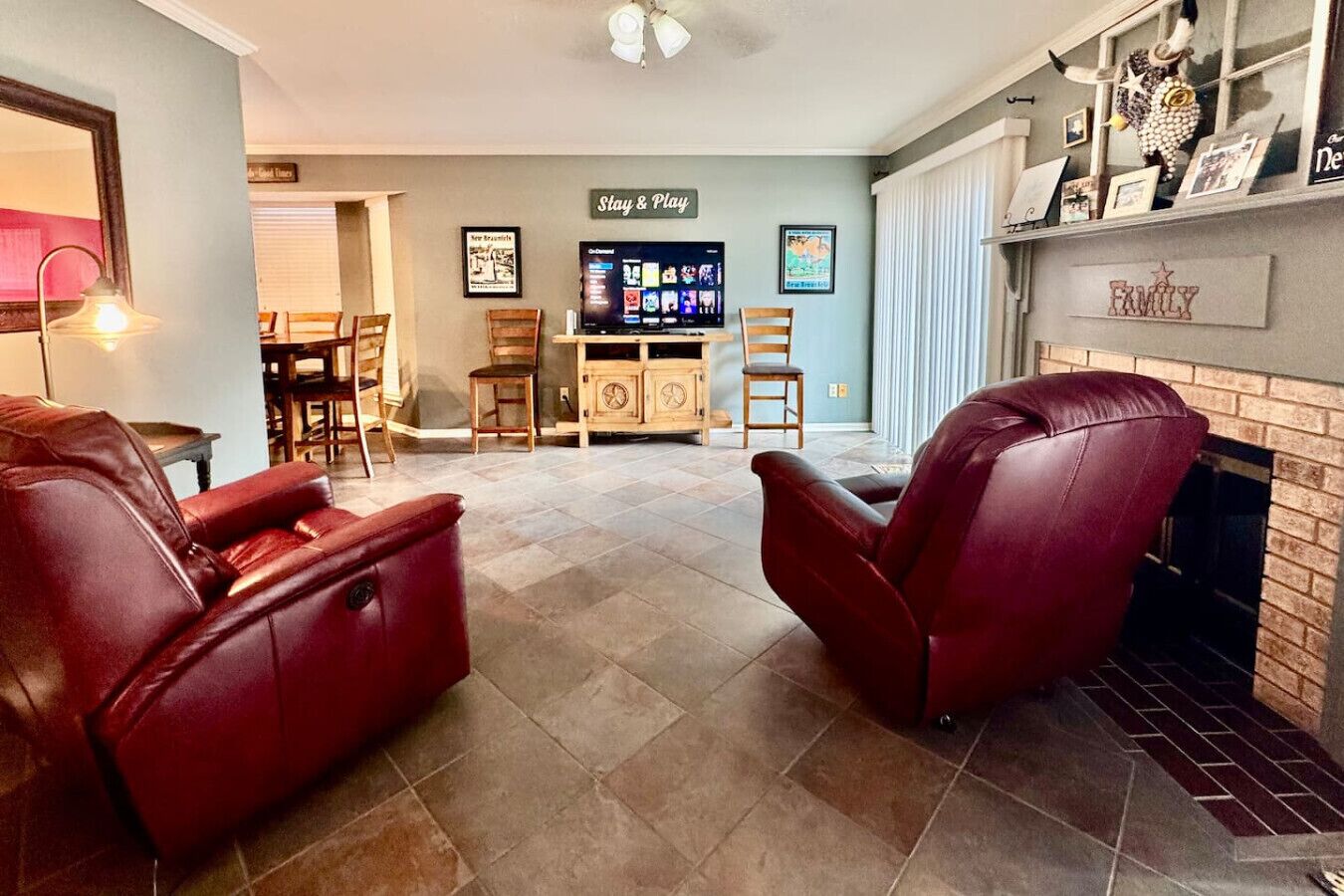 A living room with two leather recliners, a fireplace, and a television in the background.