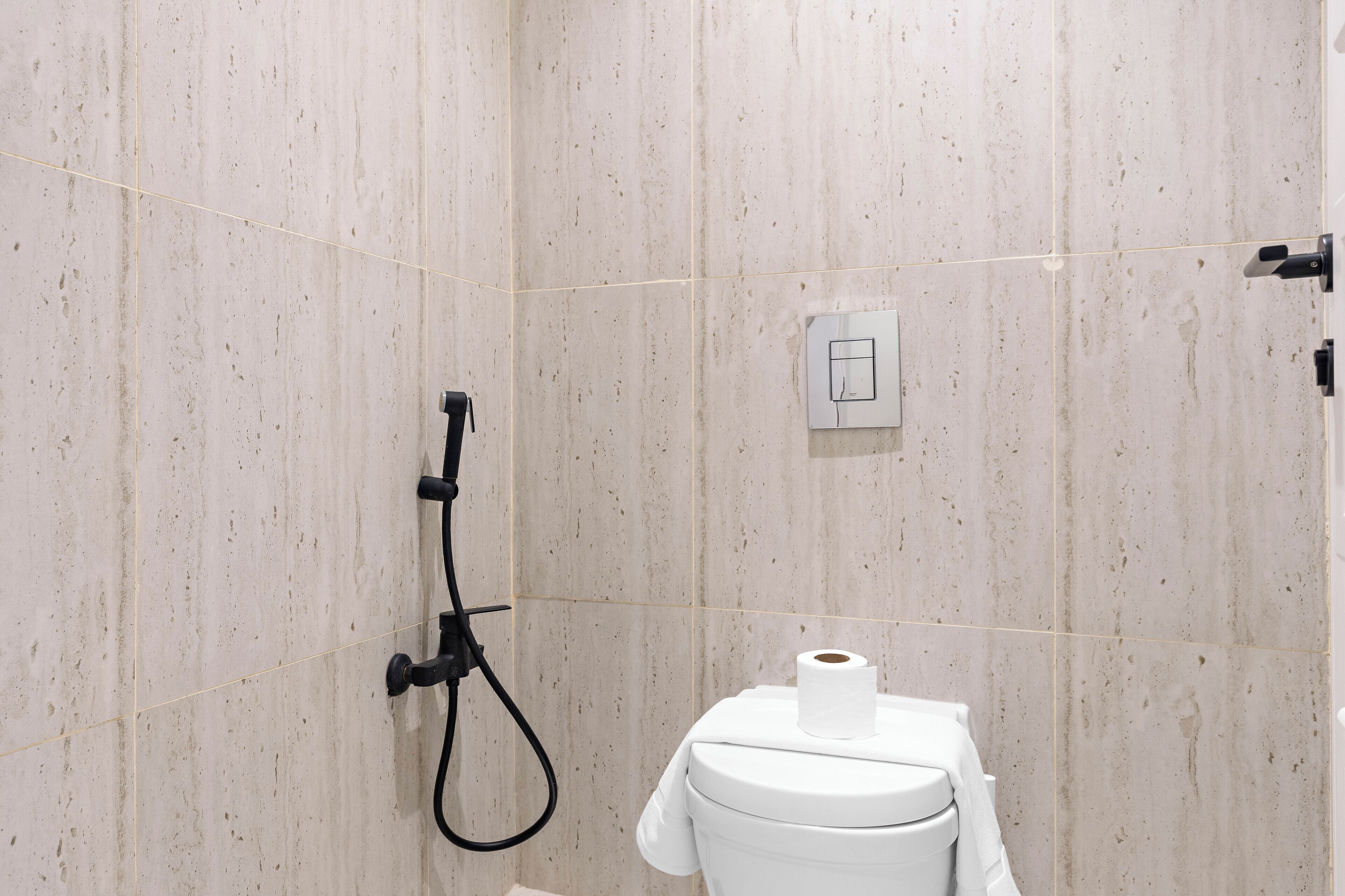 A bathroom with a shower, toilet, and towel rack.