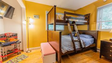 A bunk bed room with a desk and a TV.