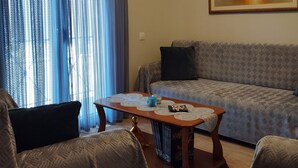 A living room with a sofa, two armchairs, a coffee table, and a painting on the wall. - Panos House - Warm and cozy retreat (Trikala)