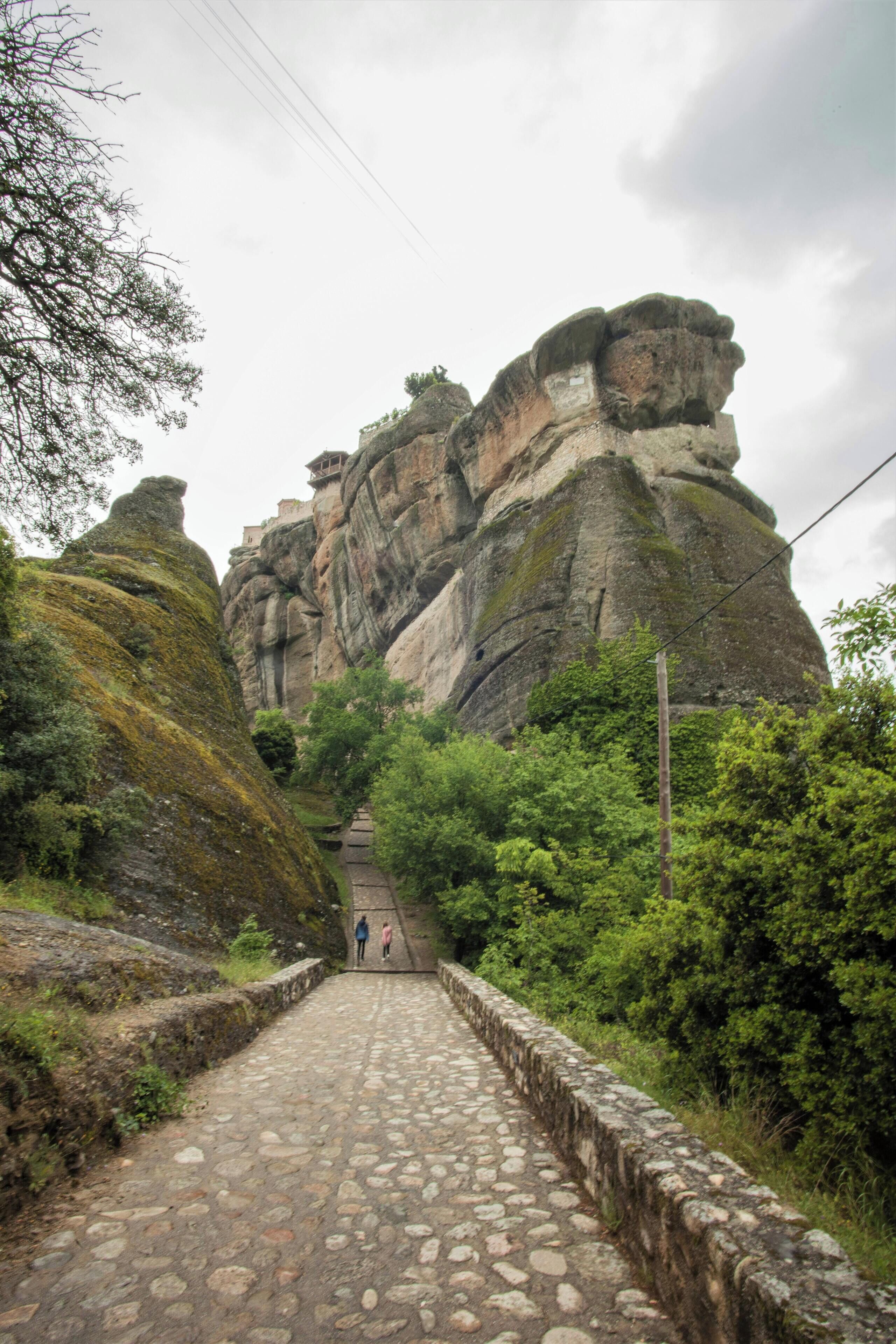 Ein steiniger Pfad führt zu einer felsigen Klippe, auf deren Spitze ein kleines Gebäude steht.