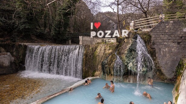 A natural hot spring with multiple waterfalls and people enjoying the water. - Panos House - Warm and cozy retreat (Trikala)