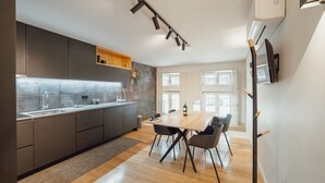 Eine moderne Küche mit grauen Schränken, einem Holztisch und einem eingebauten Backofen.