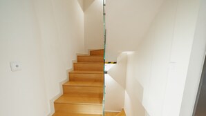 Eine Treppe mit Holzboden und Glastrennwand.
