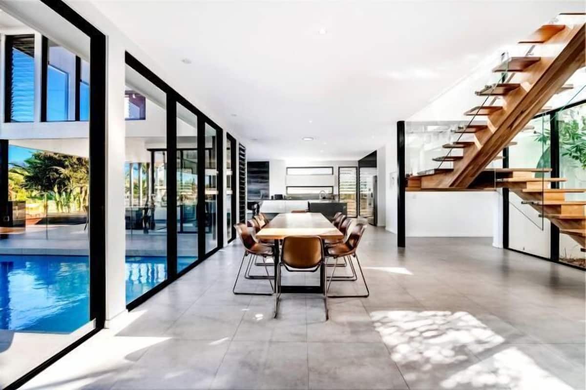 Un interno moderno con zona pranzo, piscina e scala.