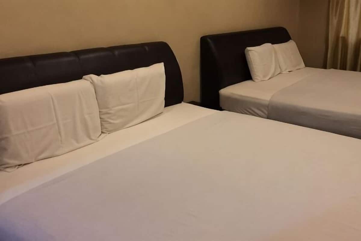 Two twin beds with black headboards and white bedding in a hotel room.