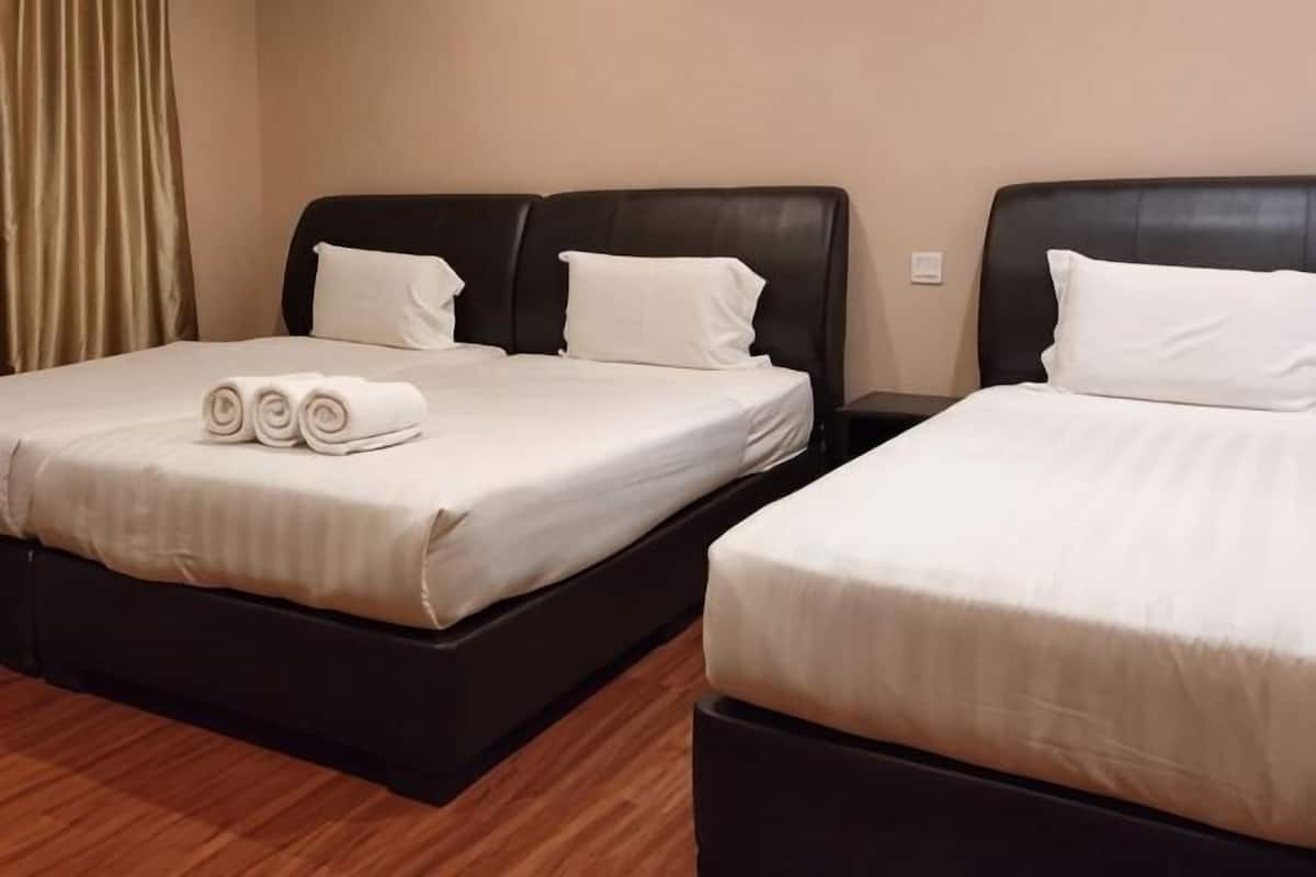 A hotel room with two beds, each with a black headboard and white bedding.