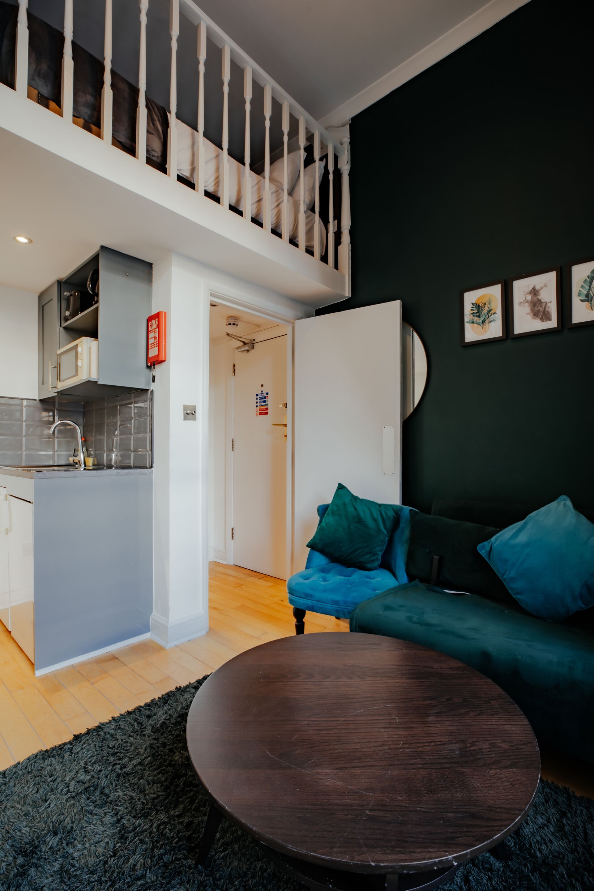 A modern living space with a kitchen, a dining area, and a staircase.