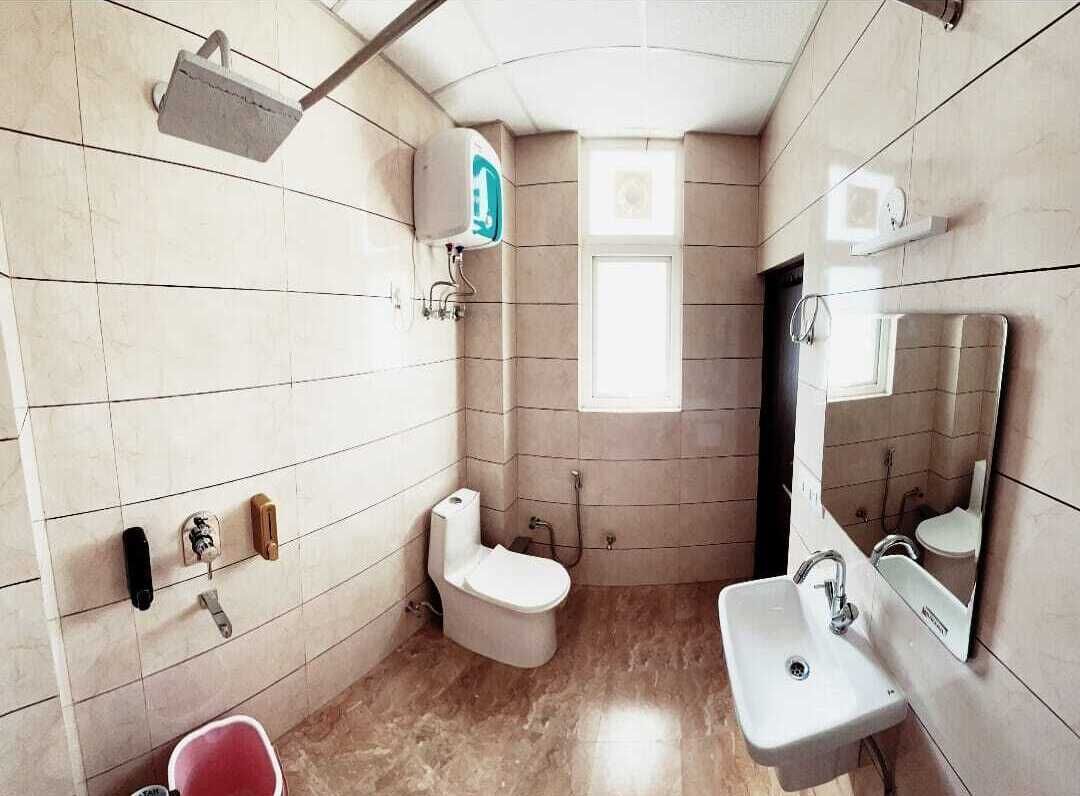 A compact bathroom with a toilet, sink, and shower.