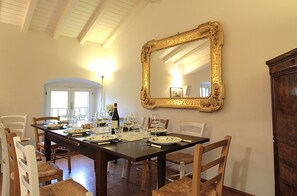 A dining room with a large ornate mirror, a wooden table set for six, and white chairs. - Il Vigneto, Verona, Pool, Wifi (Colognola Ai Colli)