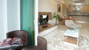 A modern living room with a sofa, a coffee table, and a dining area with a table and chairs. - TUI Blue The Haven Ipoh (Ipoh)