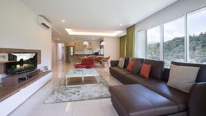 A modern living room with a large TV, a sofa, and a dining area. - TUI Blue The Haven Ipoh (Ipoh)