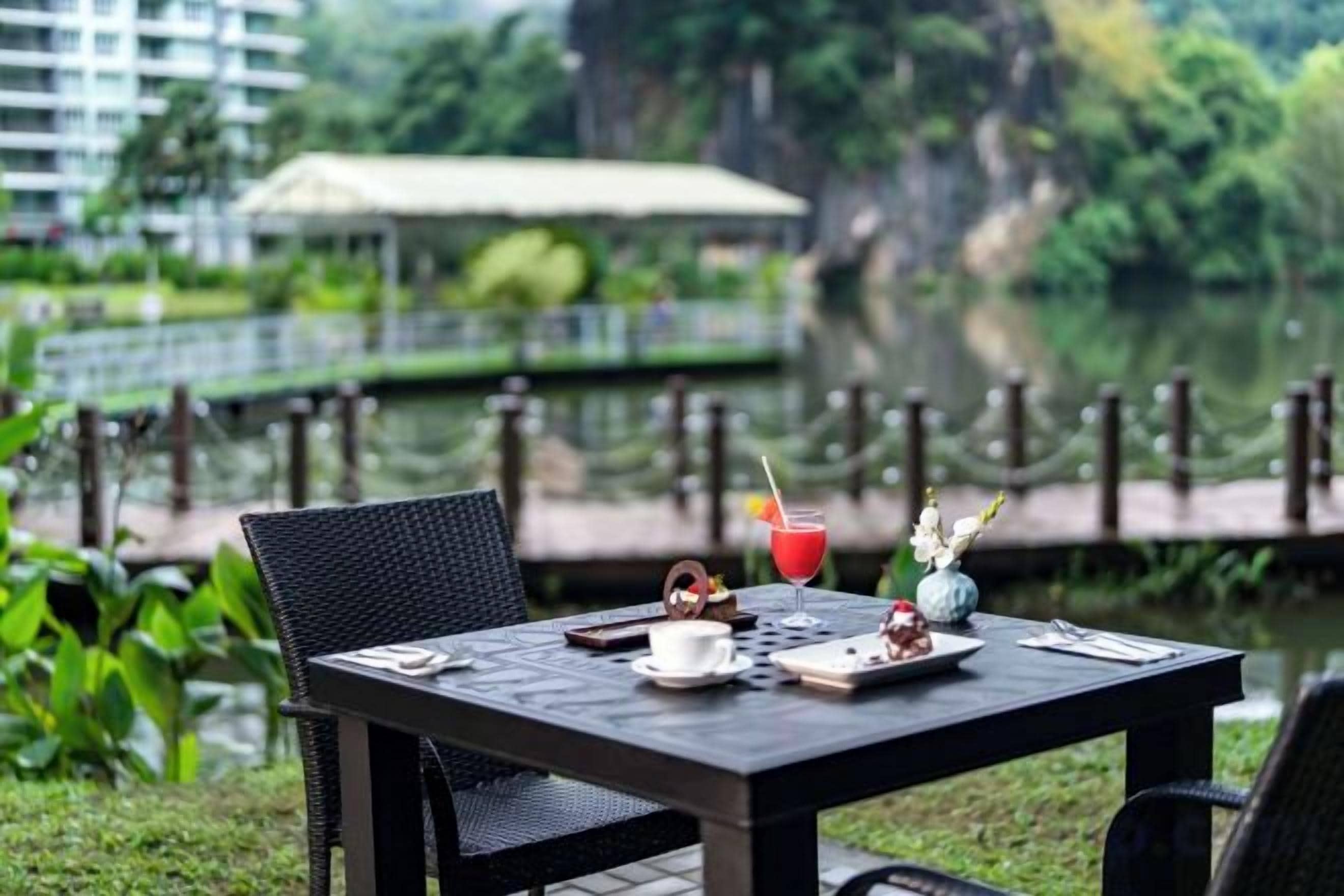 A table set outdoors with a view of a lake and greenery.