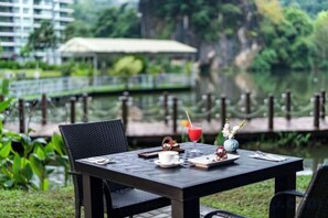 A table set outdoors with a view of a lake and greenery. - TUI BLUE The Haven Ipoh (Ipoh)
