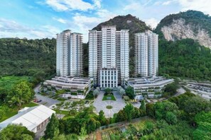 A high-rise residential building complex with multiple floors, surrounded by greenery and a mountainous backdrop. - TUI BLUE The Haven Ipoh (Ipoh)