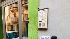 Entrada de hotel con fachada verde y balcón visible, con un letrero que indica 'Casa Vacanza'.