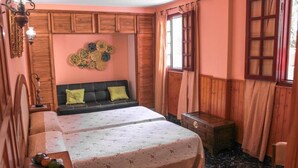 A bedroom with a bed, bedside table, and a chest of drawers.