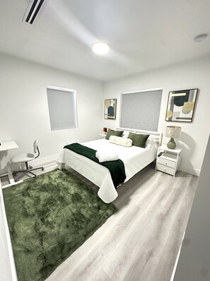 2 habitaciones, escritorio y tabla de planchar con plancha