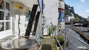 Een gebouw aan de kust met een balkon met uitzicht op een rotsachtige kustlijn.