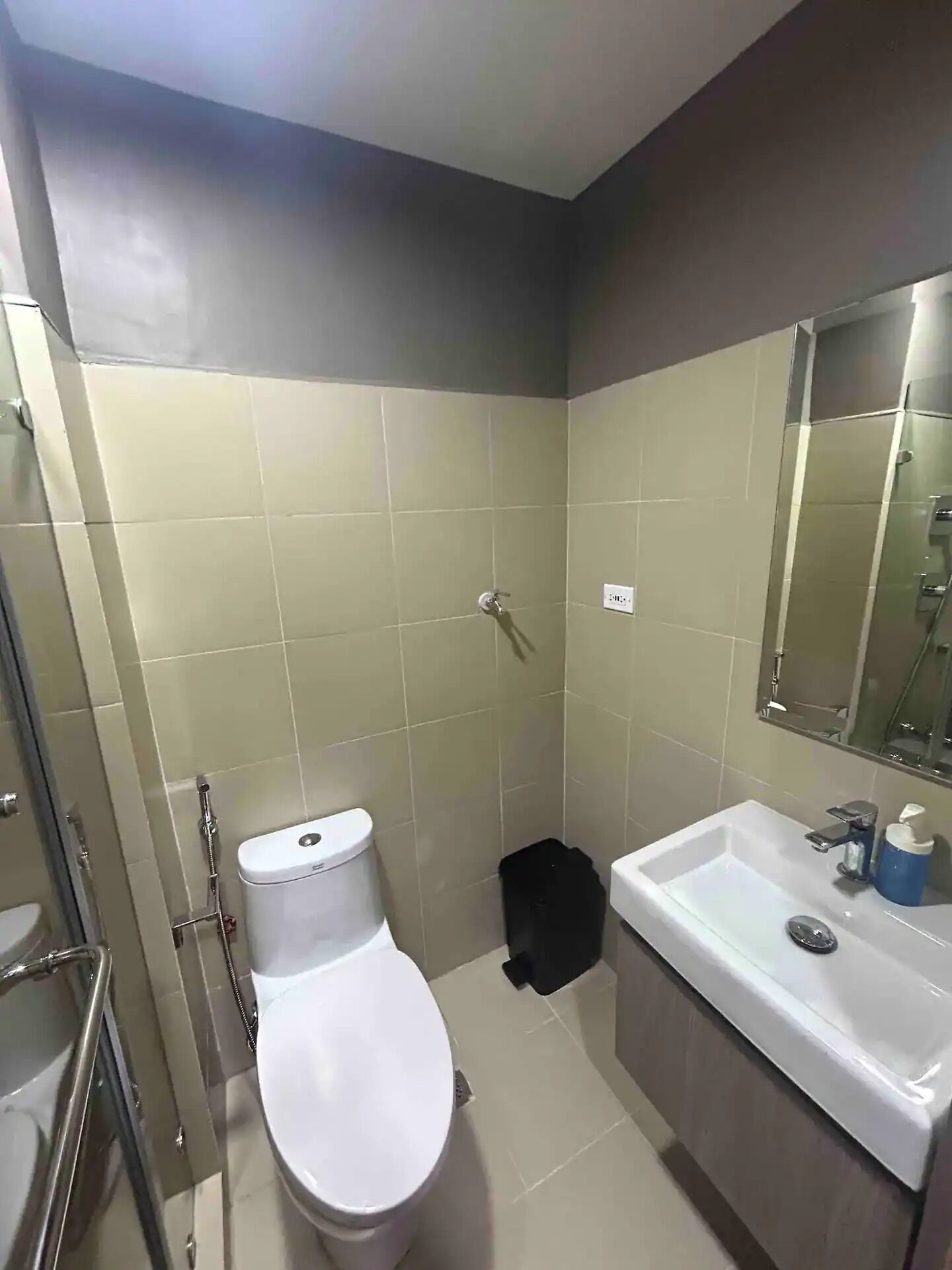 A bathroom with a toilet, sink, and shower area.