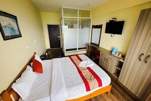 Ein Hotelzimmer mit Bett, Kleiderschrank, Fernseher und Badezimmer.