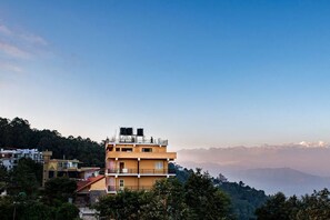 Un edificio a più piani con tetto piatto e un balcone al piano superiore.