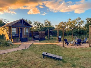 Un chalet rustique doté d’une véranda, d’un espace salon extérieur et d’un coin barbecue.