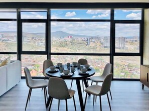 Enjoy meals with a city view from this dining area featuring a round table and four chairs.
