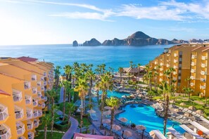 A resort with a pool, palm trees, and a view of the sea. - 3BD Ocean Penthouse Villa Del Palmar (Cabo San Lucas)