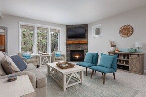 TV connectée, cheminée, table de tennis de table, livres