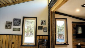 A cozy room with wooden walls and ceiling, large windows, and a fireplace. - Colorado Cottage located at 7200 feet, near to Colorado Springs. (Elbert)