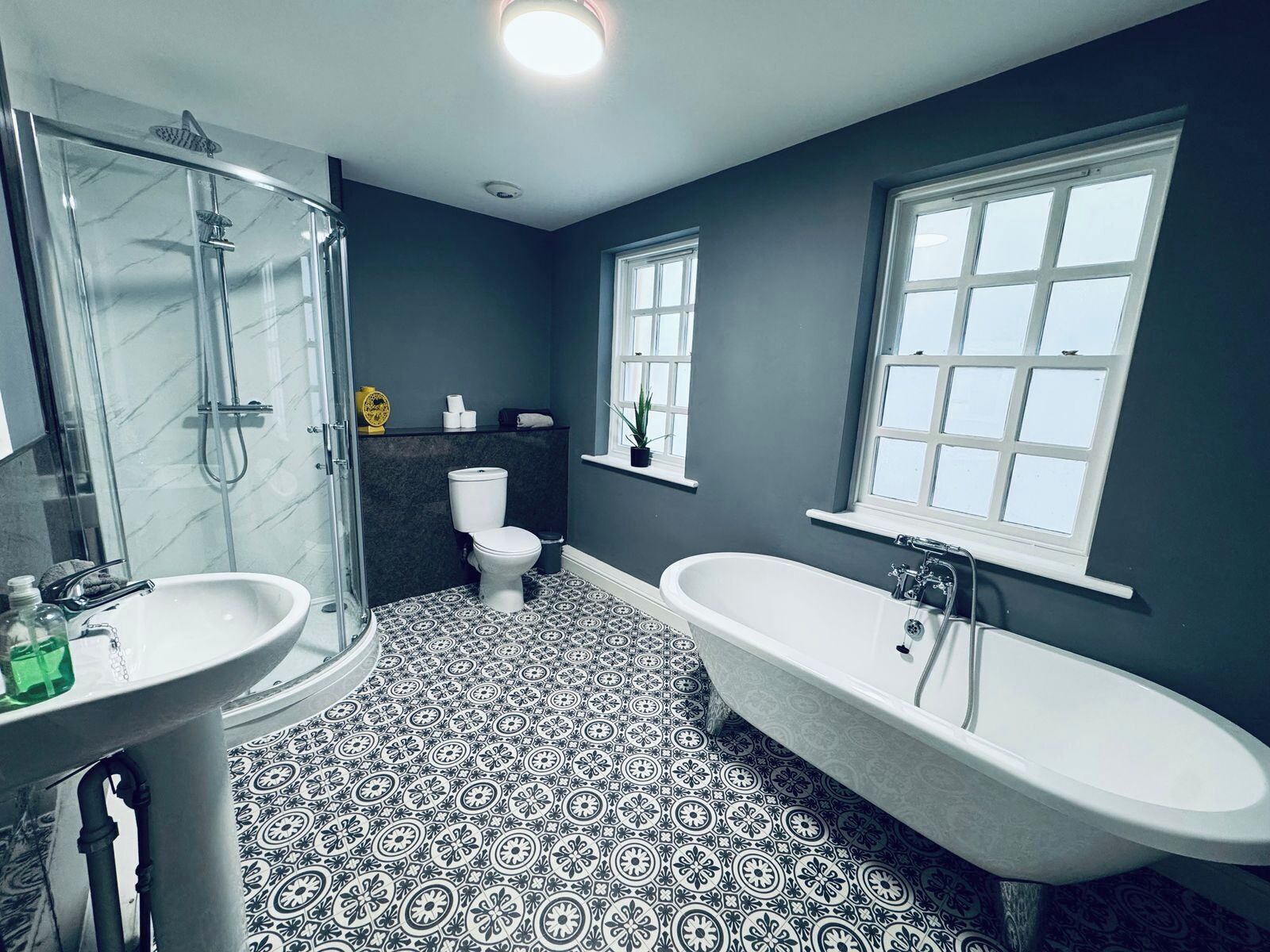A bathroom with a shower, toilet, sink, and bathtub.