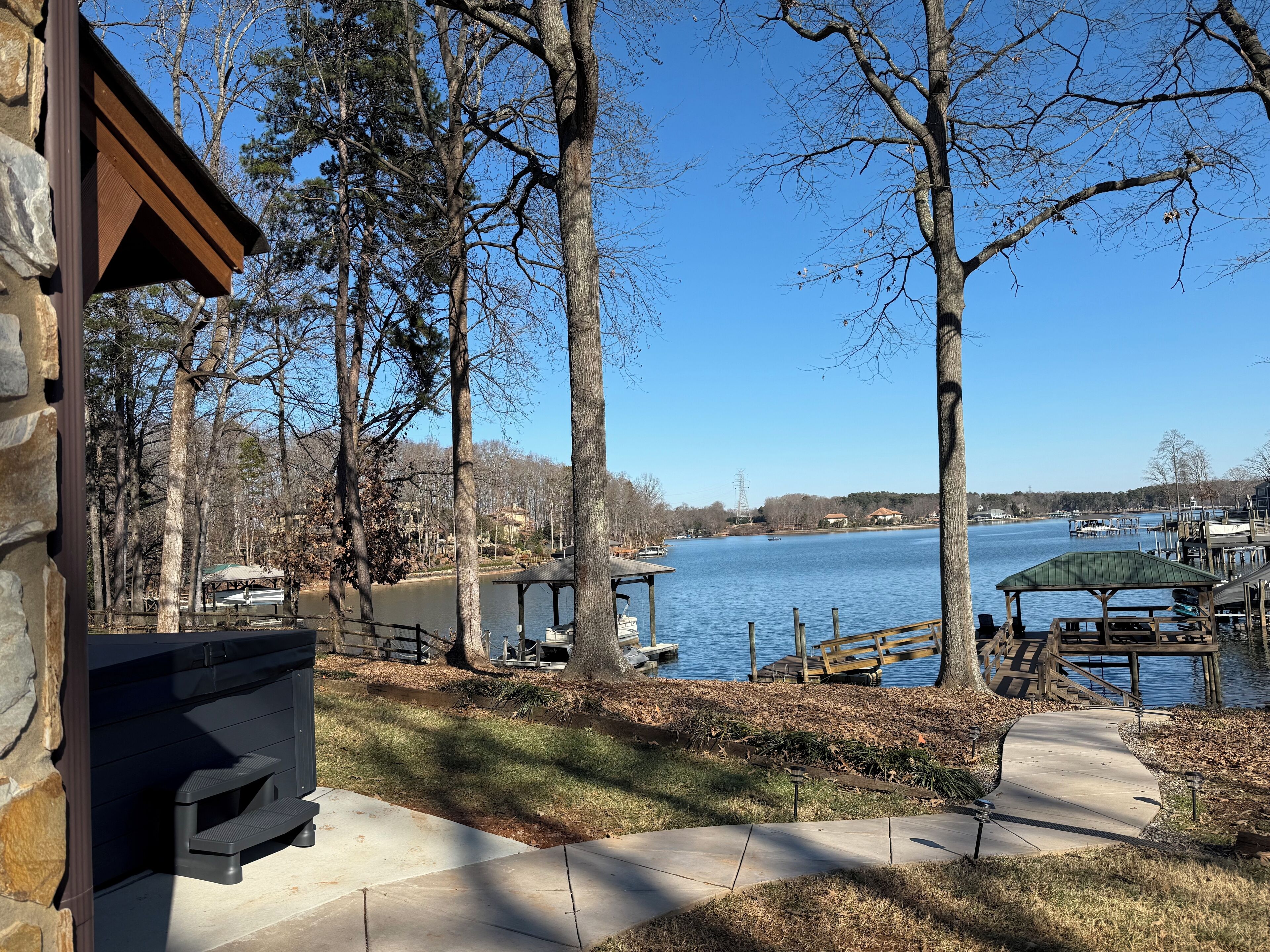 A lakeside view with a stone building, wooden deck, and dock area.