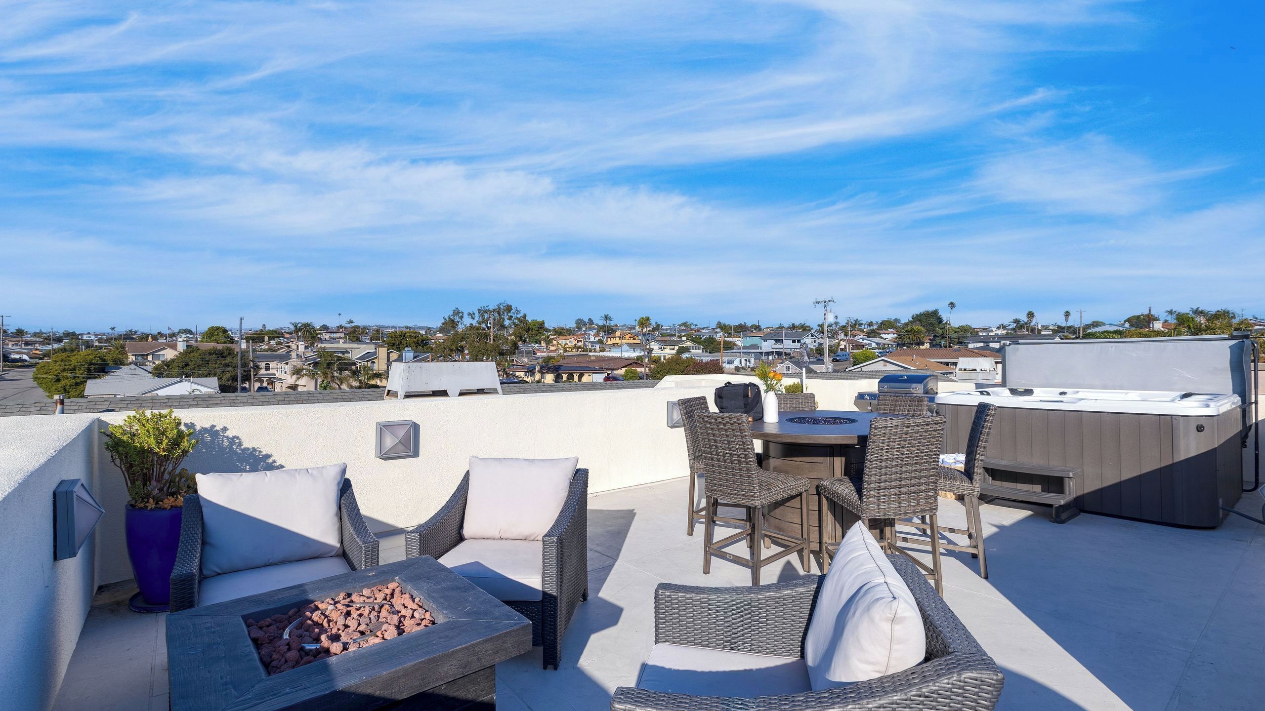 Une terrasse sur le toit, aménagée avec du mobilier d’extérieur, un barbecue et un jacuzzi.