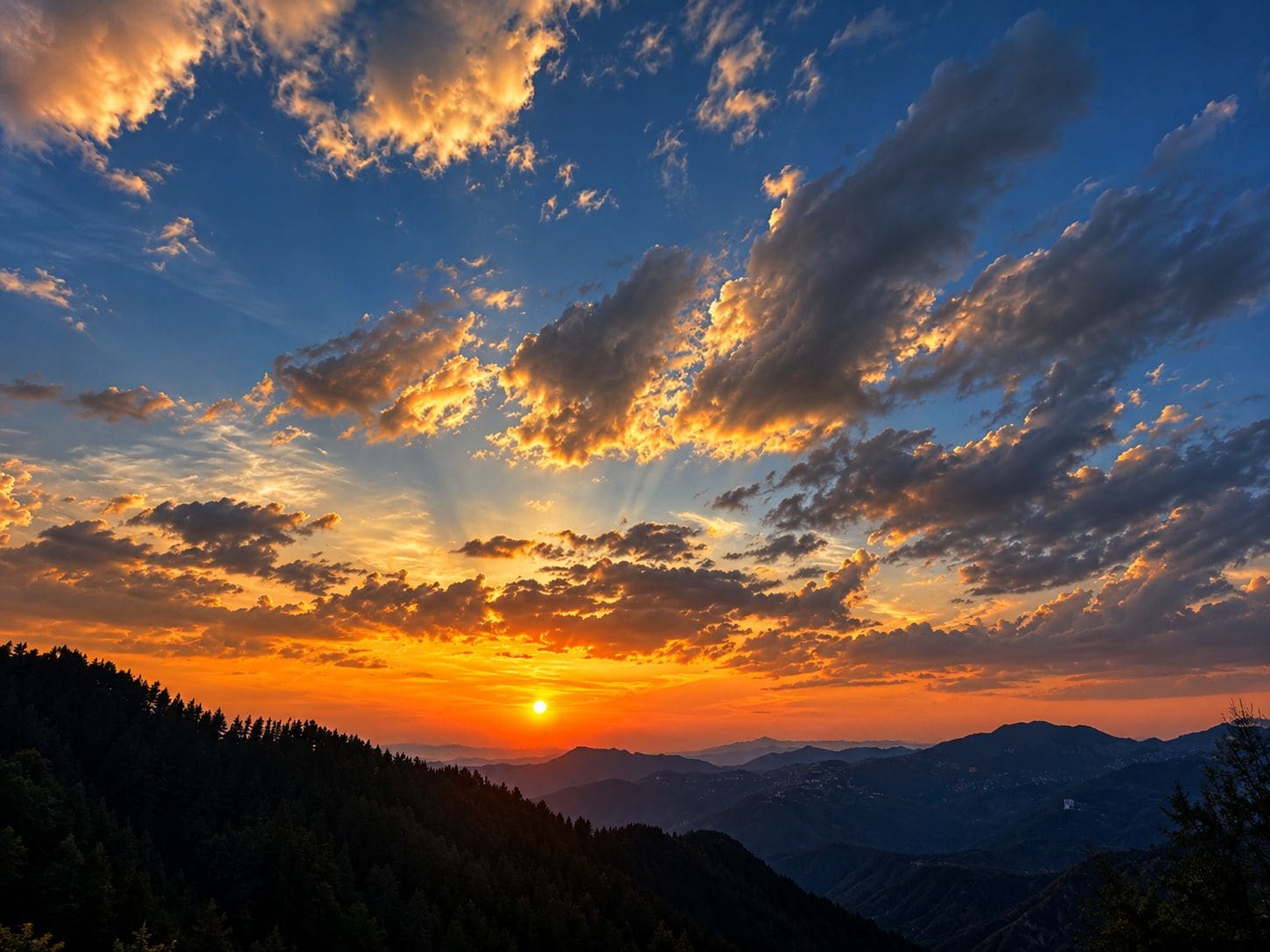 A mountain landscape with a sunset and scattered clouds.