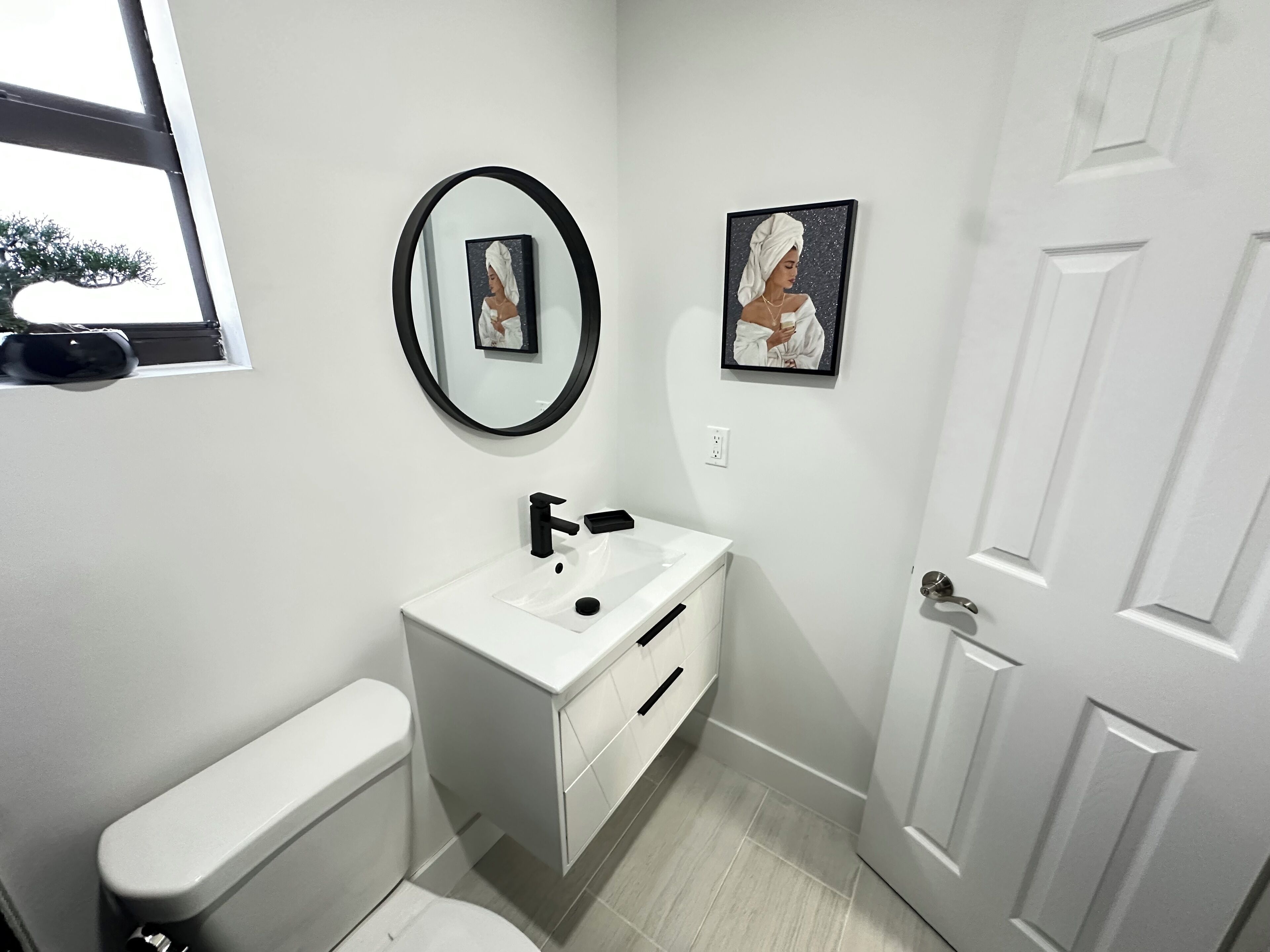 Une salle de bain moderne avec des toilettes, un lavabo et un miroir.