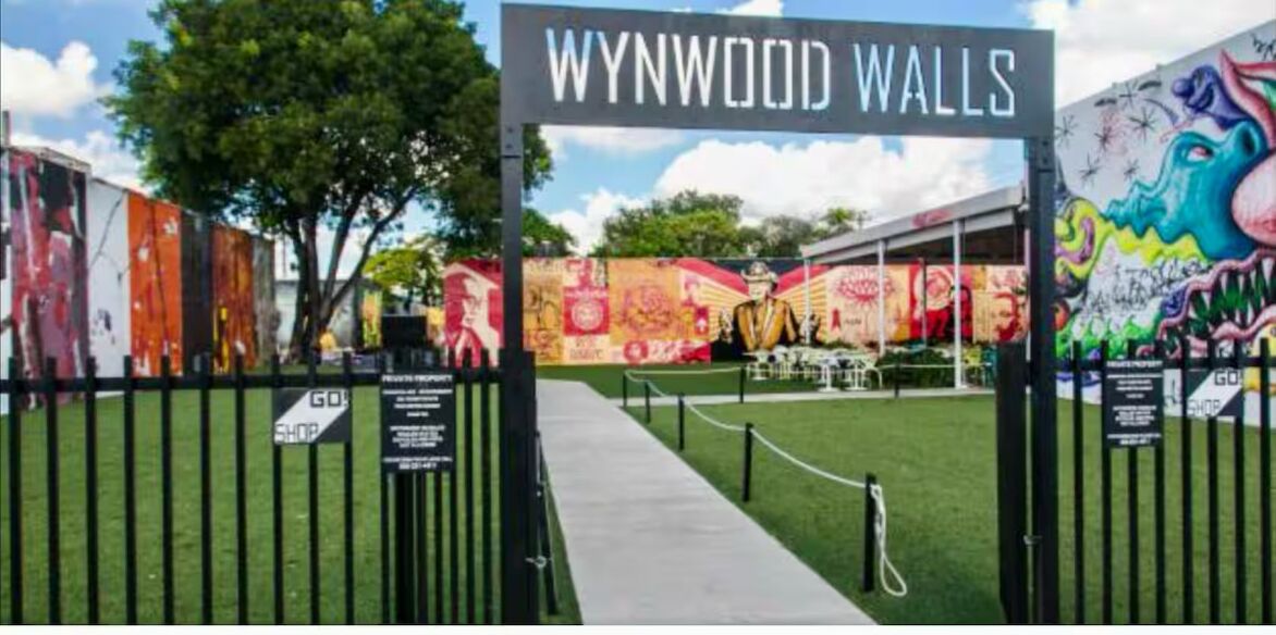 Une entrée fermée par un portail mène à Wynwood Walls, et une fresque colorée orne la clôture.