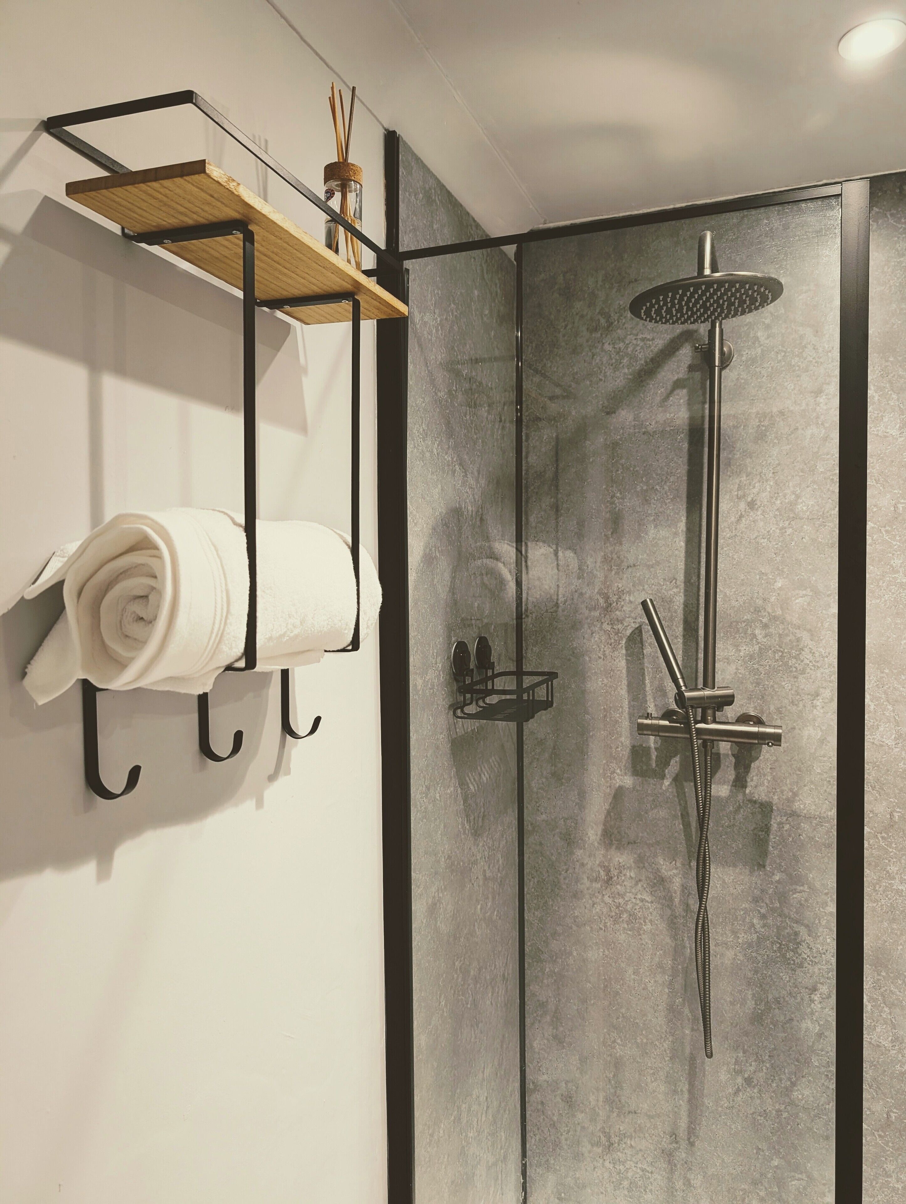 Een douche, handdoeken, zeep, toiletpapier