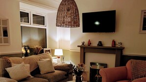 A living room with a sofa set, a coffee table, a TV, and a fireplace. - Ty Hiraeth 

A Charming Stay Steps Away from Caerphilly Castle!
 (Caerphilly)