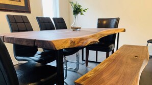 Uma mesa de jantar com tampo de madeira e cadeiras de couro preto.