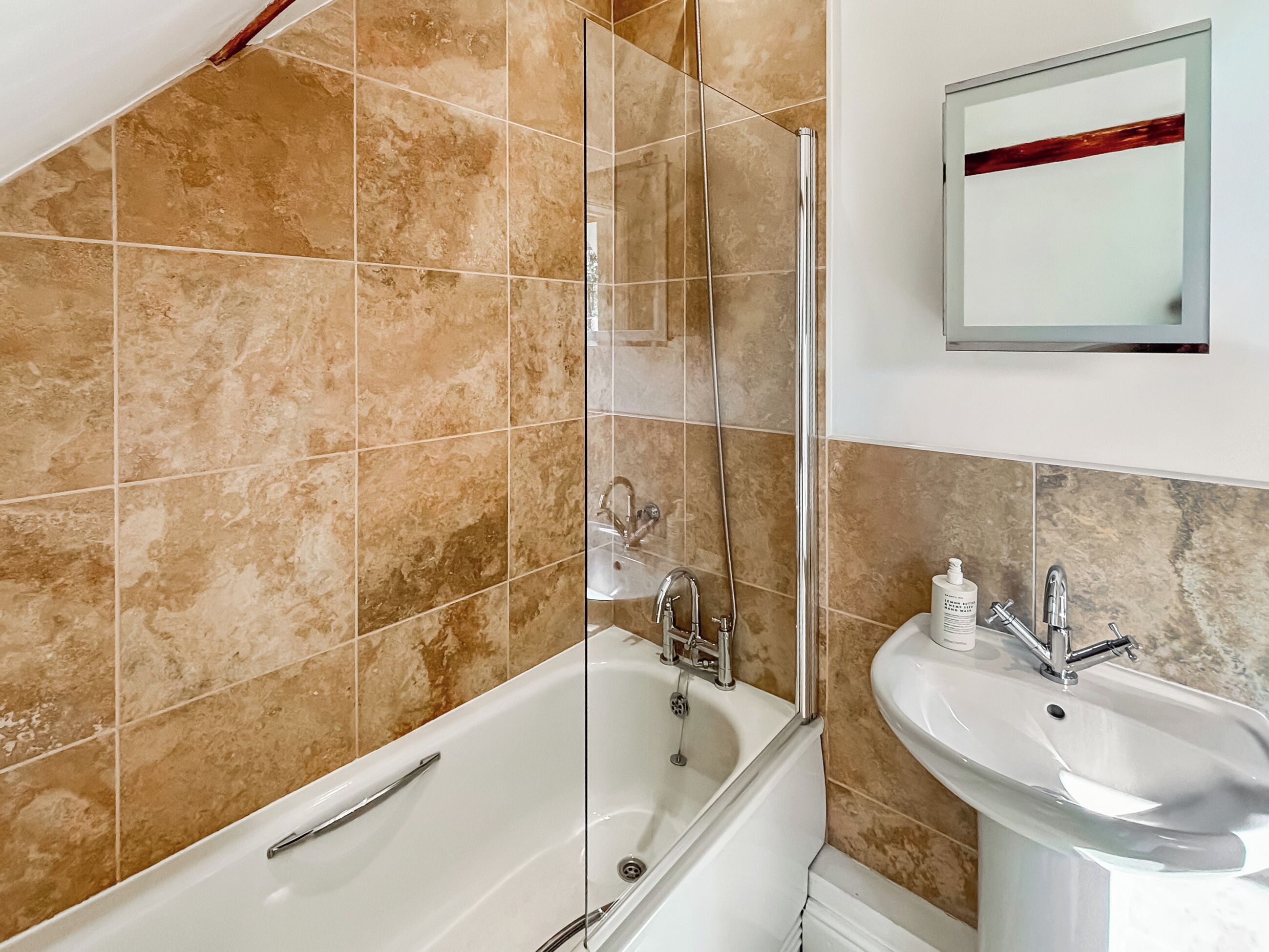 A bathroom with a bathtub, a shower, and a sink.