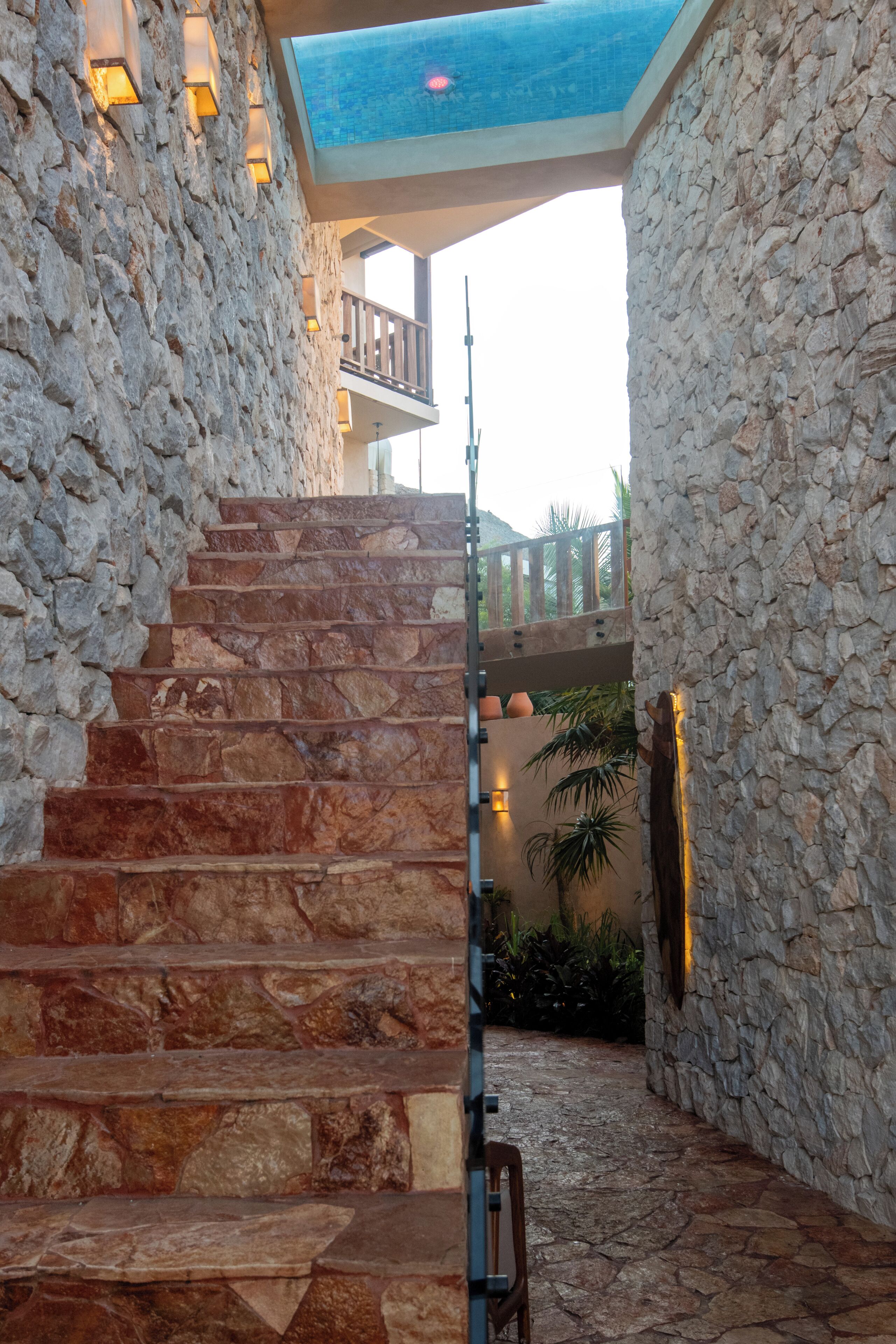 A stone staircase leading to a balcony with a view of a mountain.